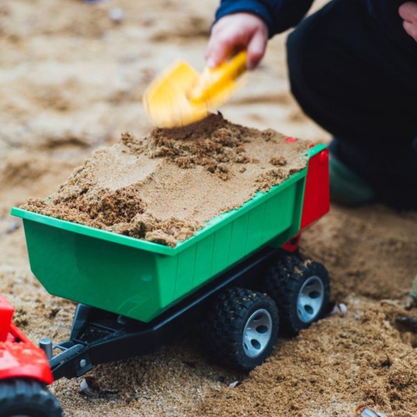 Child filling a truck with sand
